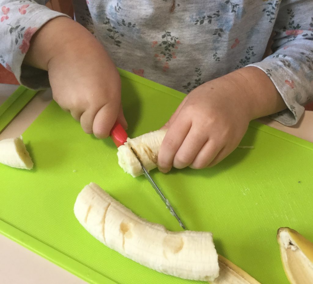 Child cutting banana